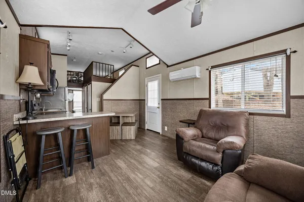 a living room with furniture a ceiling fan and a large window