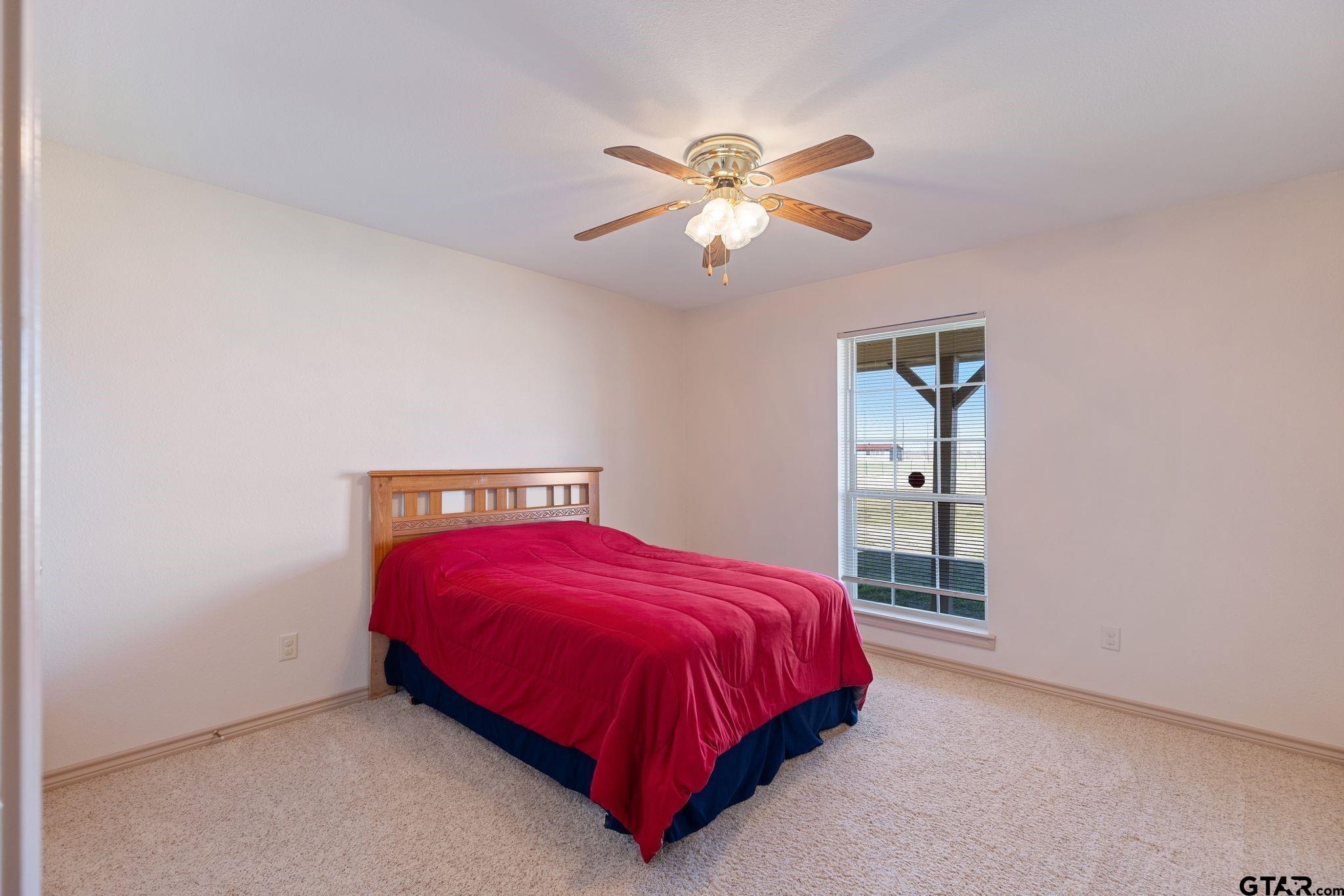 4 County Road 3566 Dike, TX 75437 - Photo 19 of 36 a bedroom with a bed and a chandelier