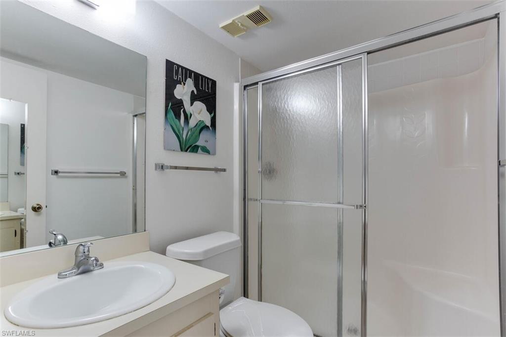 4351 27th Court Southwest, Unit 203 Naples, FL 34116 - Photo 18 of 34 Bathroom with walk in shower, vanity, and toilet