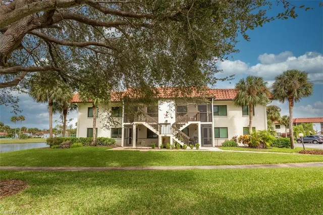 a view of a house with a big yard and large trees