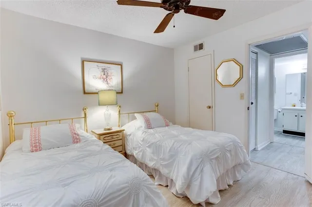 a bedroom with two beds and painting on the wall