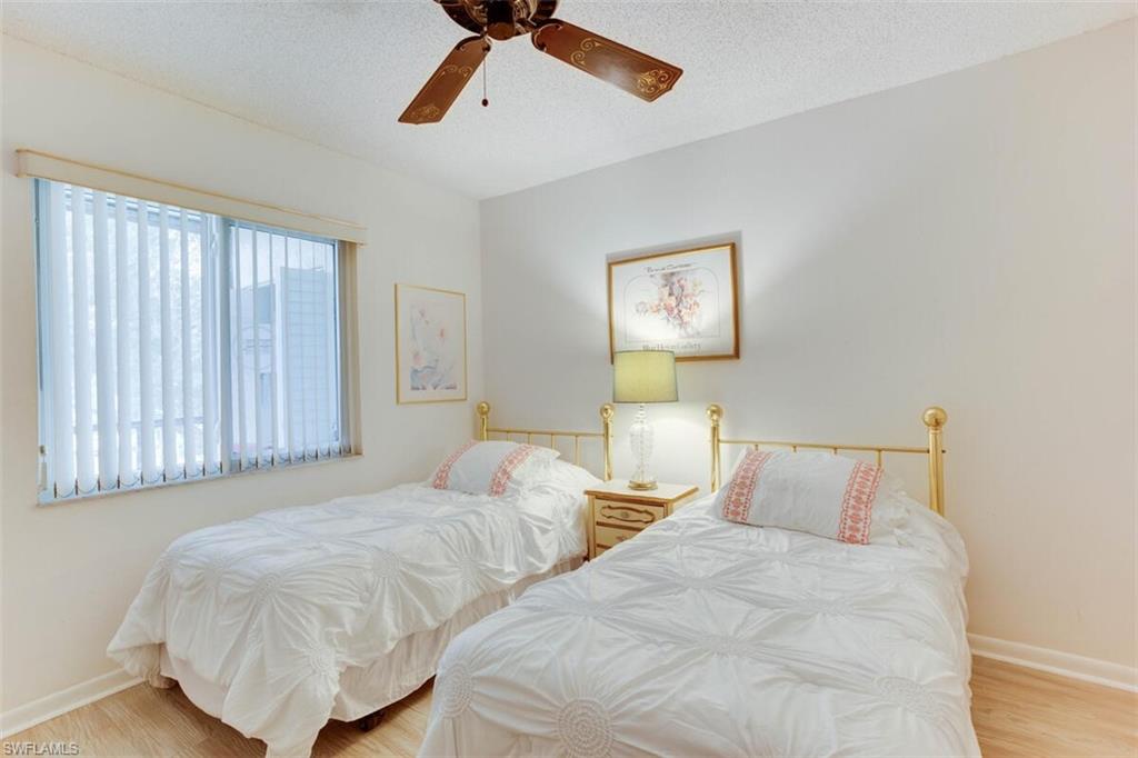4351 27th Court Southwest, Unit 203 Naples, FL 34116 - Photo 23 of 34 Bedroom featuring a textured ceiling, light hardwood / wood-style floors, and ceiling fan