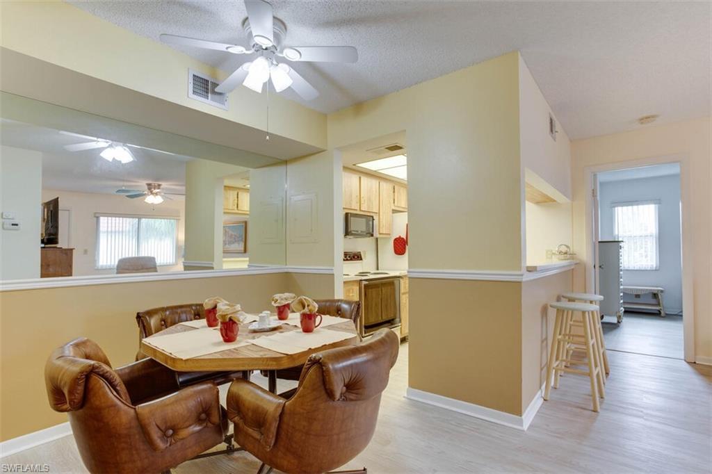 4351 27th Court Southwest, Unit 203 Naples, FL 34116 - Photo 4 of 34 Dining room with light hardwood / wood-style floors, a healthy amount of sunlight, and ceiling fan