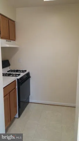 a kitchen with granite countertop a white stove and white cabinets