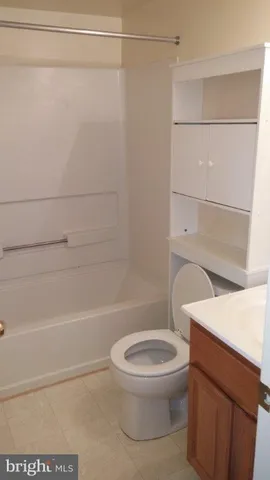 a white toilet sitting next to a bath tub