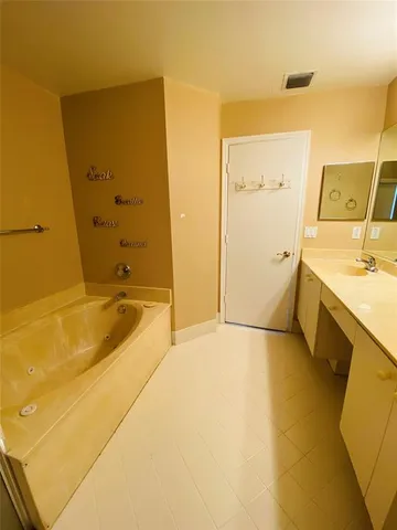 a bathroom with a tub sink and mirror