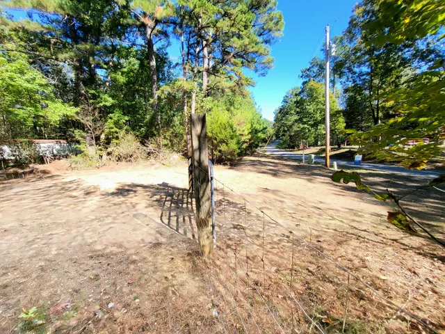 a view of dirt field with trees in the background