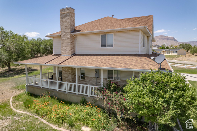 190 600 North Ferron, UT 84523 - Photo 71 of 85 Side view of property featuring a chimney, roof with shingles, a porch, and a mountain view
