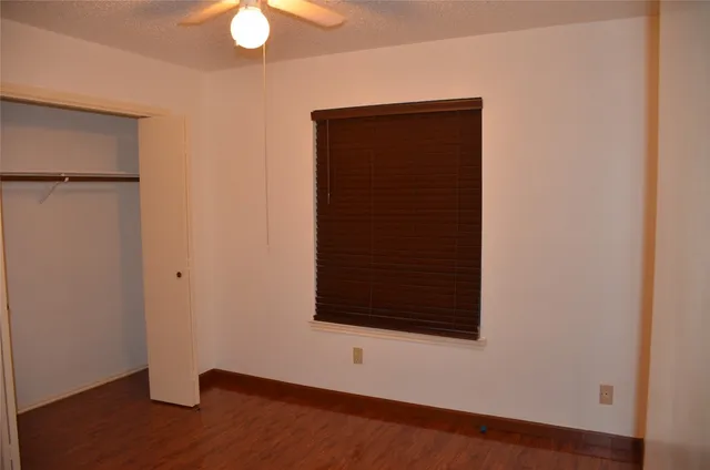 an empty room with wooden floor and closet