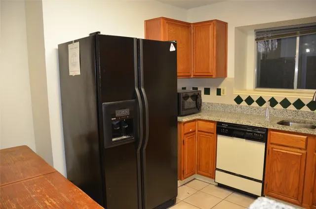a kitchen with stainless steel appliances granite countertop a refrigerator and a sink