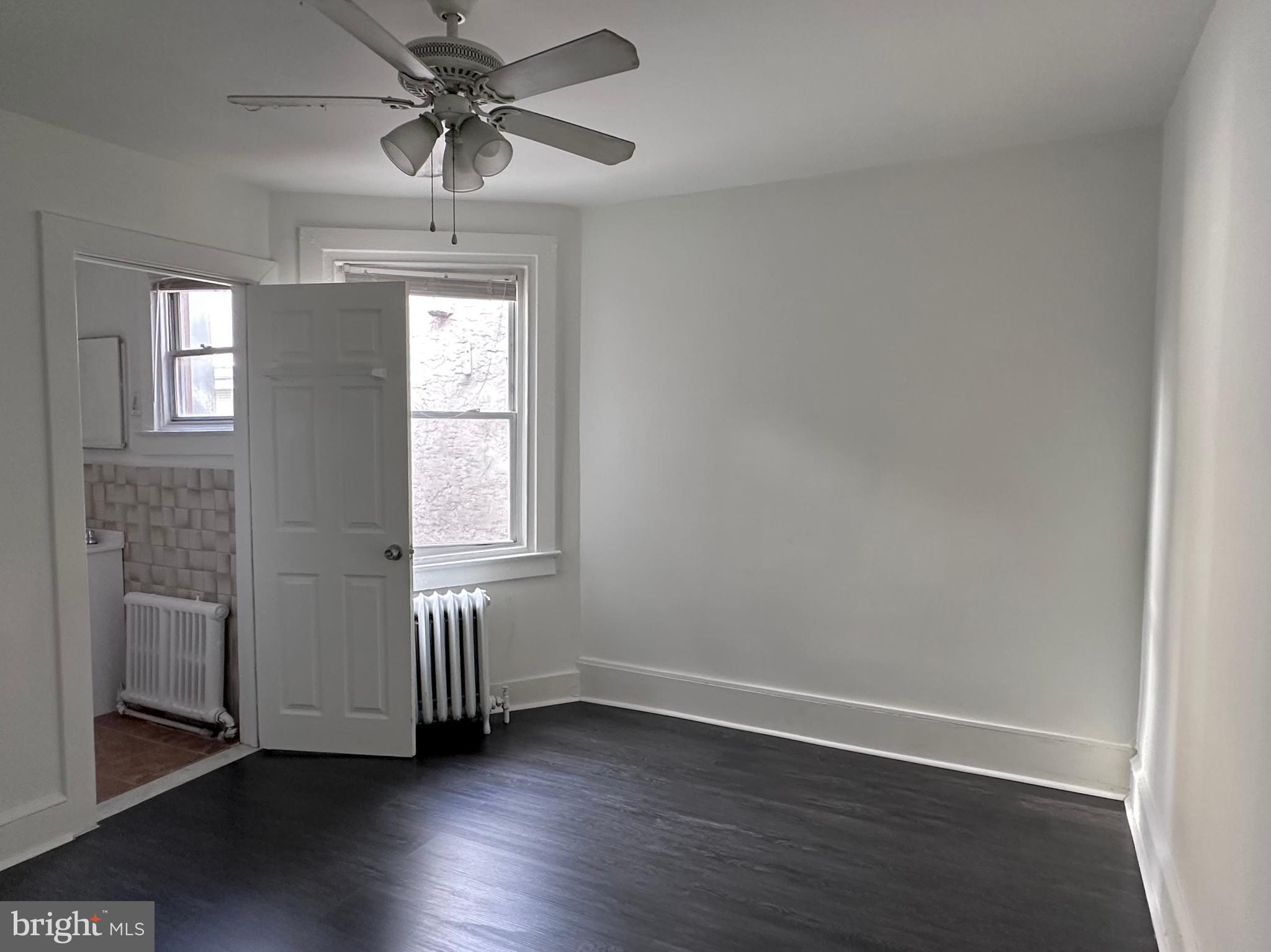 411 Burmont Road Drexel Hill, PA 19026 - Photo 14 of 28 an empty room with wooden floor chandelier fan and windows