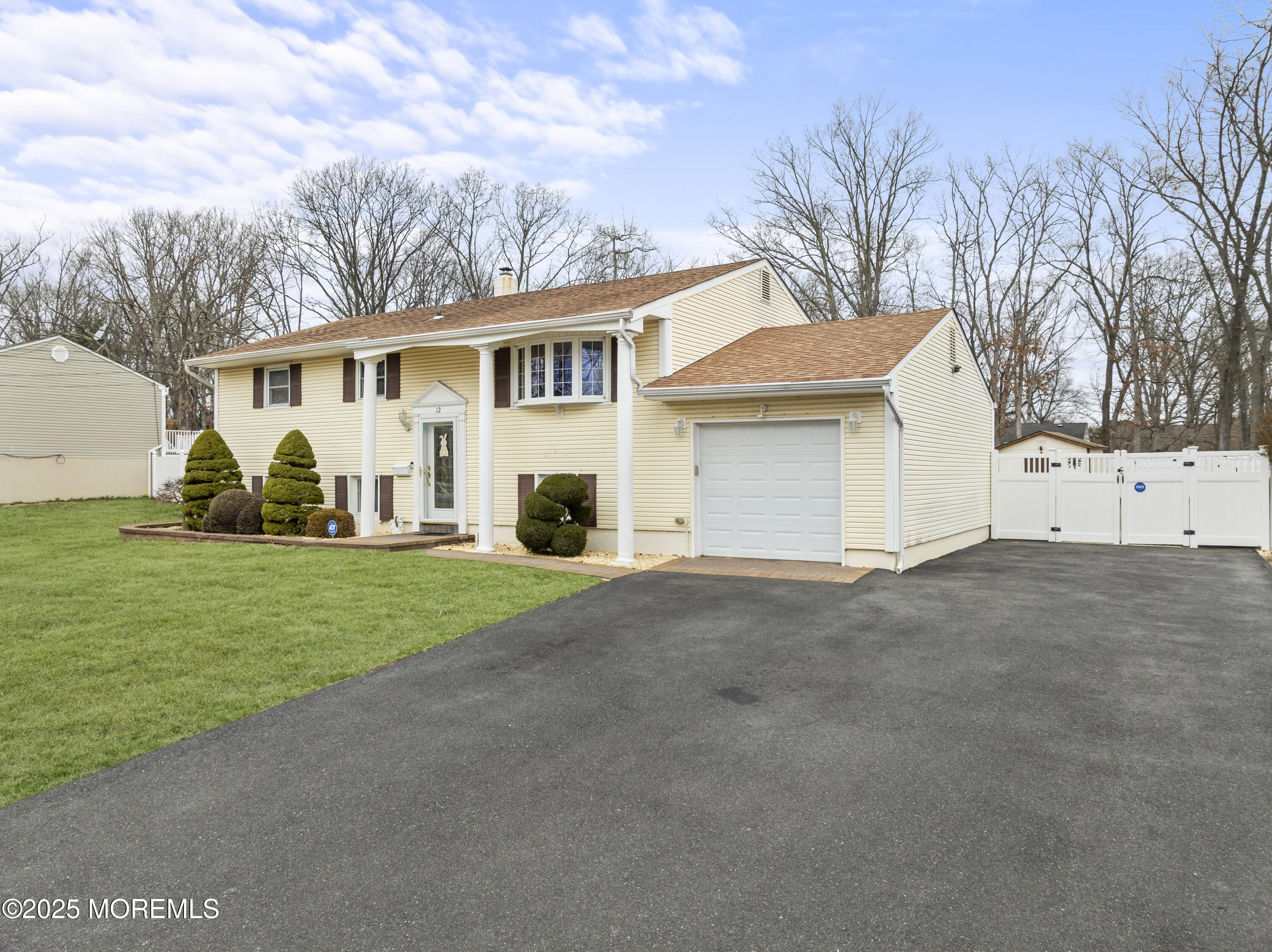 12 Nottingham Drive Howell, NJ 07731 - Photo 2 of 34 a view of a yard in front of a house with plants and large tree