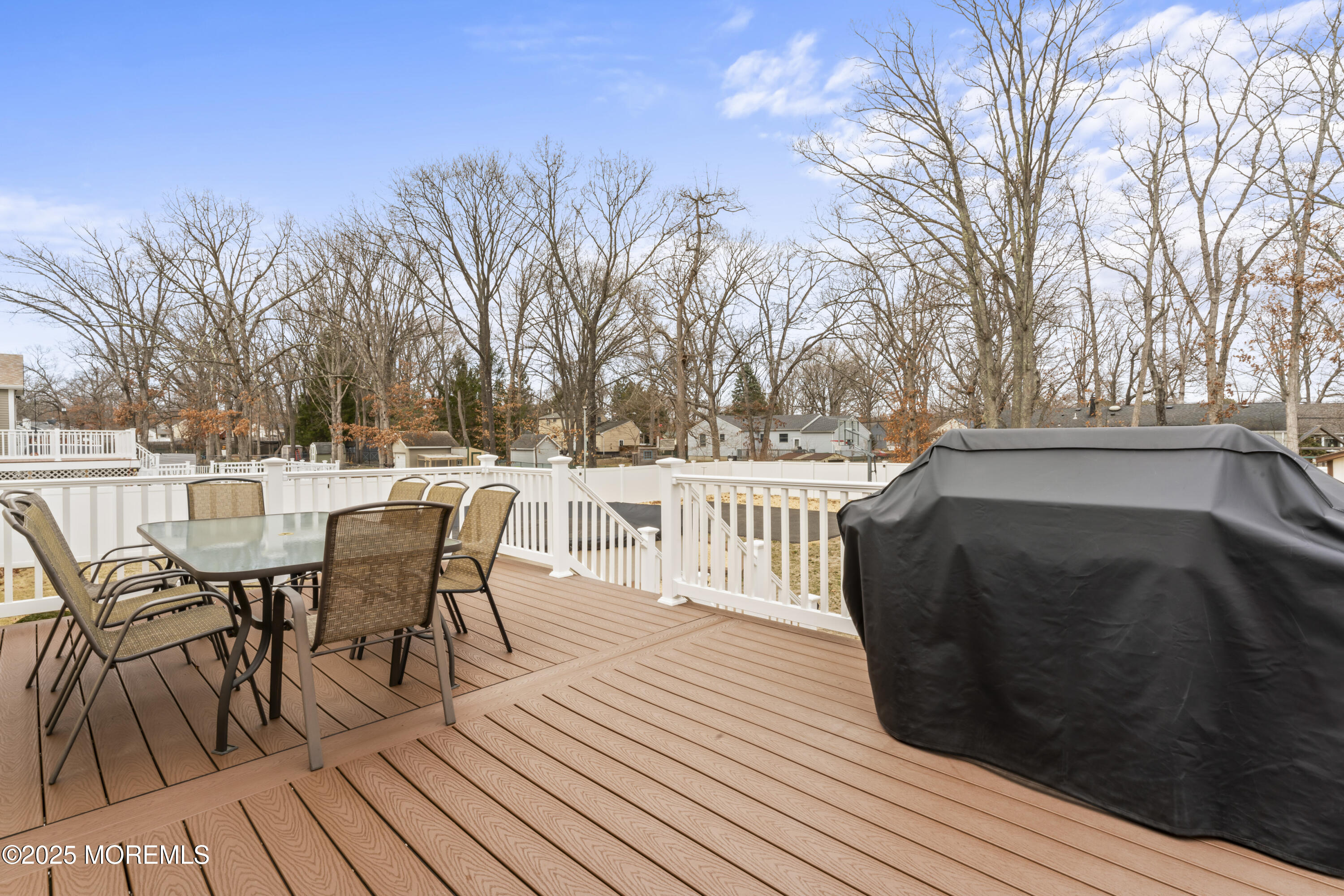 12 Nottingham Drive Howell, NJ 07731 - Photo 21 of 34 a view of a roof deck with table and chairs couches and a barbeque with wooden fence and floor