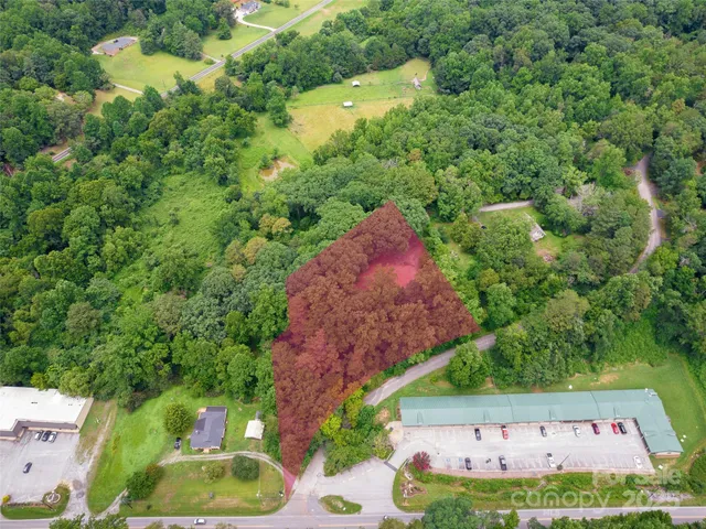 an aerial view of residential house with outdoor space and trees all around