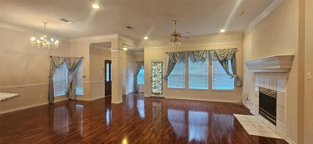 a view of a hallway with wooden floor stairs and a livingroom