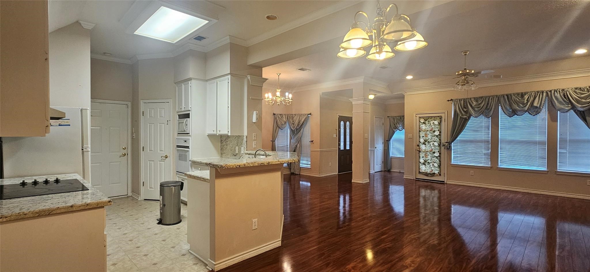 1903 North Travis Street Liberty, TX 77575 - Photo 7 of 13 a kitchen with stainless steel appliances kitchen island granite countertop a table chairs refrigerator and a stove