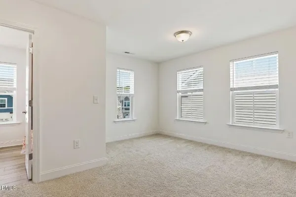 a spacious bedroom with a bed and a chandelier
