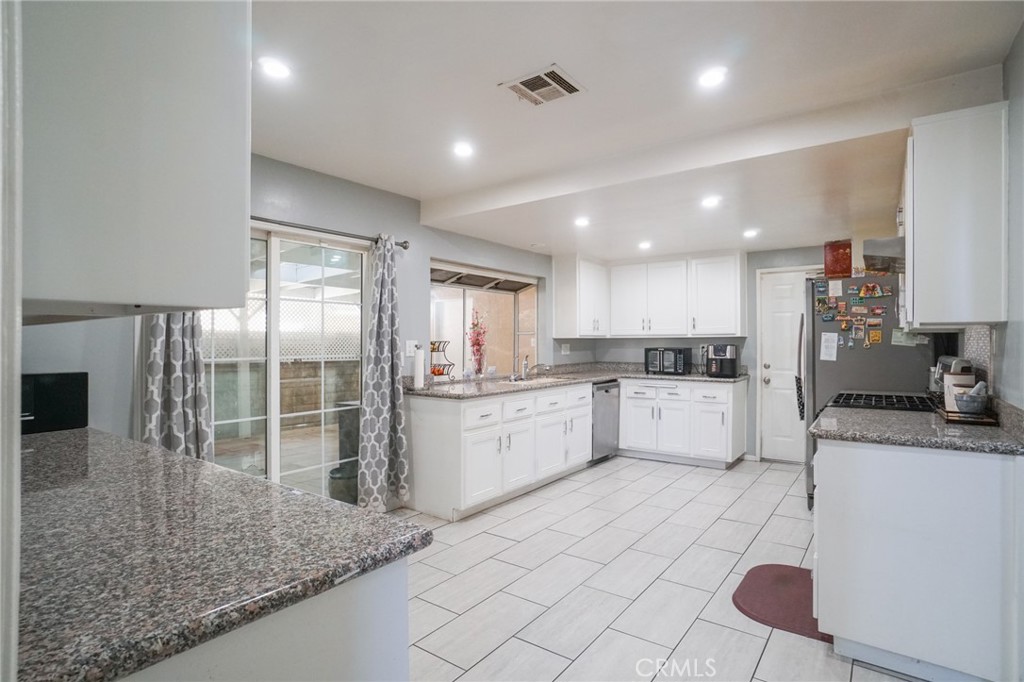 19259 Kenya Street Porter Ranch, CA 91326 - Photo 6 of 31 a large kitchen with kitchen island a sink stainless steel appliances and cabinets