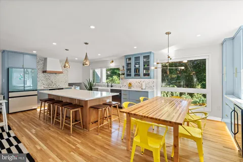 a living room with stainless steel appliances kitchen island granite countertop furniture and a wooden floor
