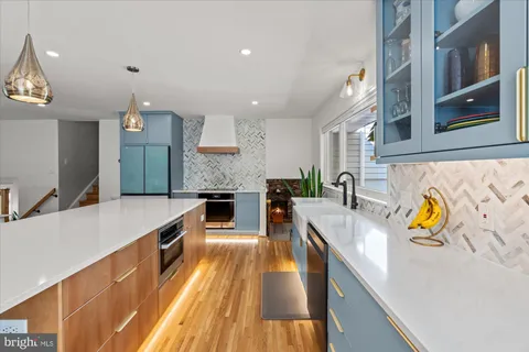 a large kitchen with stainless steel appliances granite countertop a large counter top and a stove