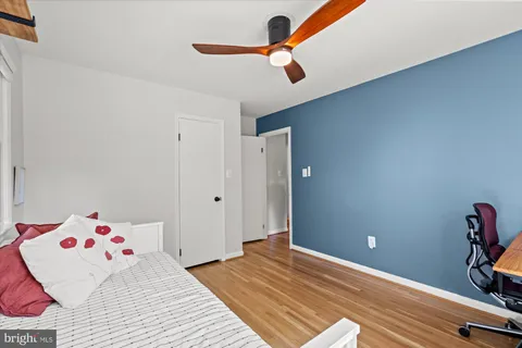 a bedroom with a bed and wooden floor