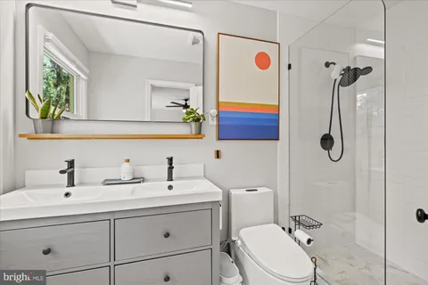 a bathroom with a sink a toilet and shower