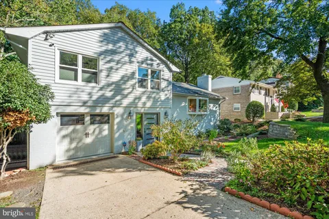 a view of a house with a small yard and potted plants