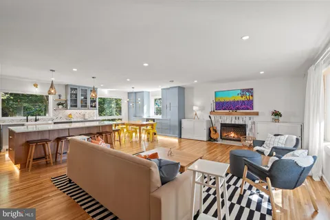a living room with furniture a fireplace and a kitchen view