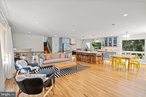 a living room with lots of furniture and kitchen view with wooden floor