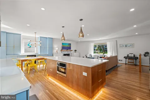 a large kitchen with stainless steel appliances a large counter top a stove and a sink