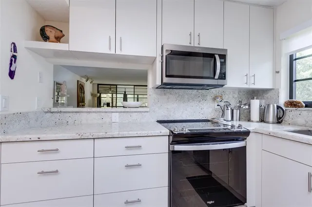 a kitchen with appliances a sink and a window