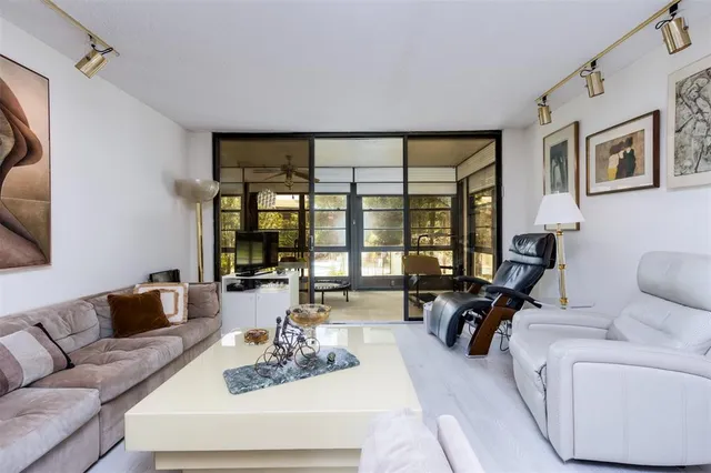 a living room with furniture and floor to ceiling windows