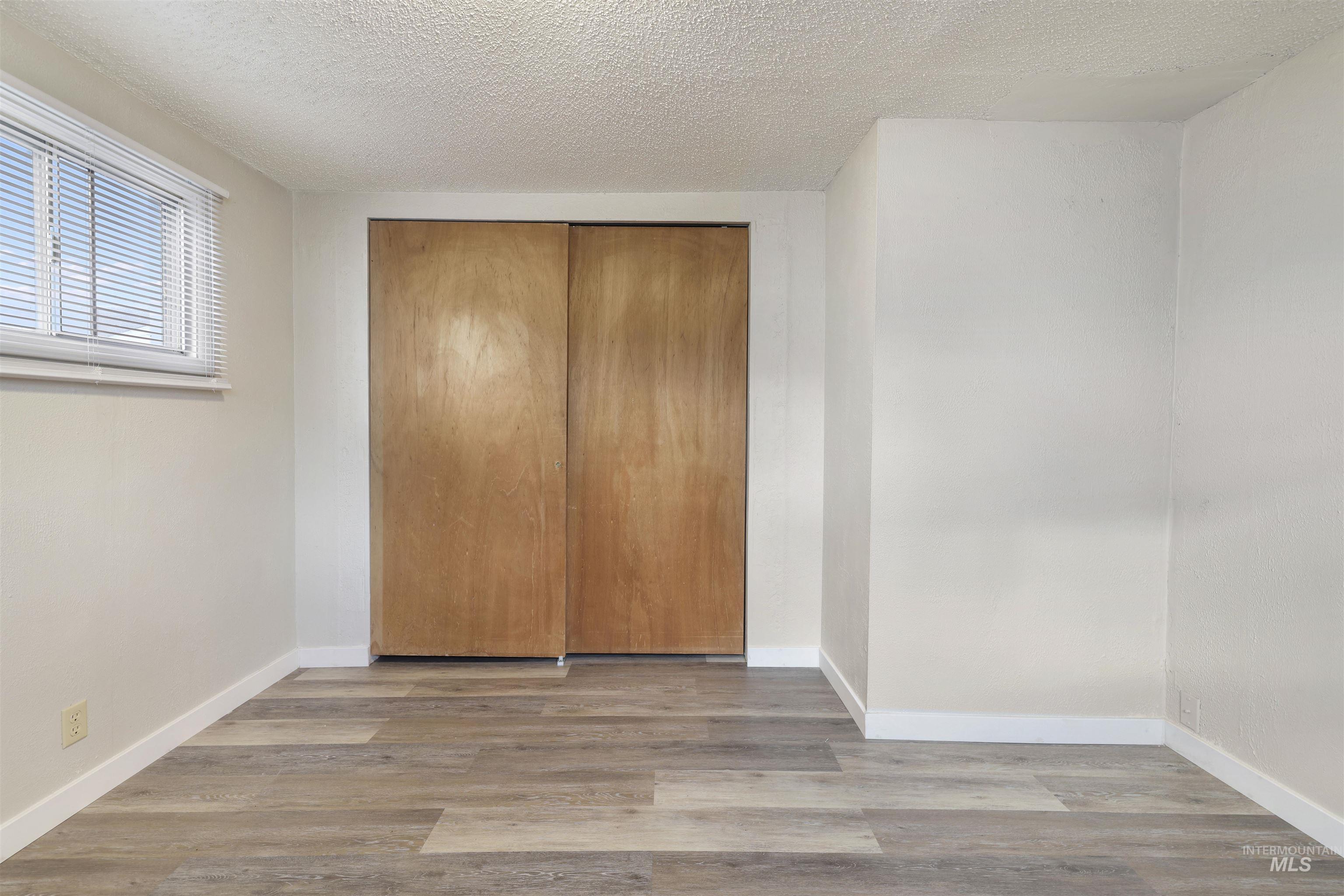 545 Madison Street Twin Falls, ID 83301 - Photo 17 of 23 Unfurnished bedroom with a textured ceiling, wood finished floors, and a closet