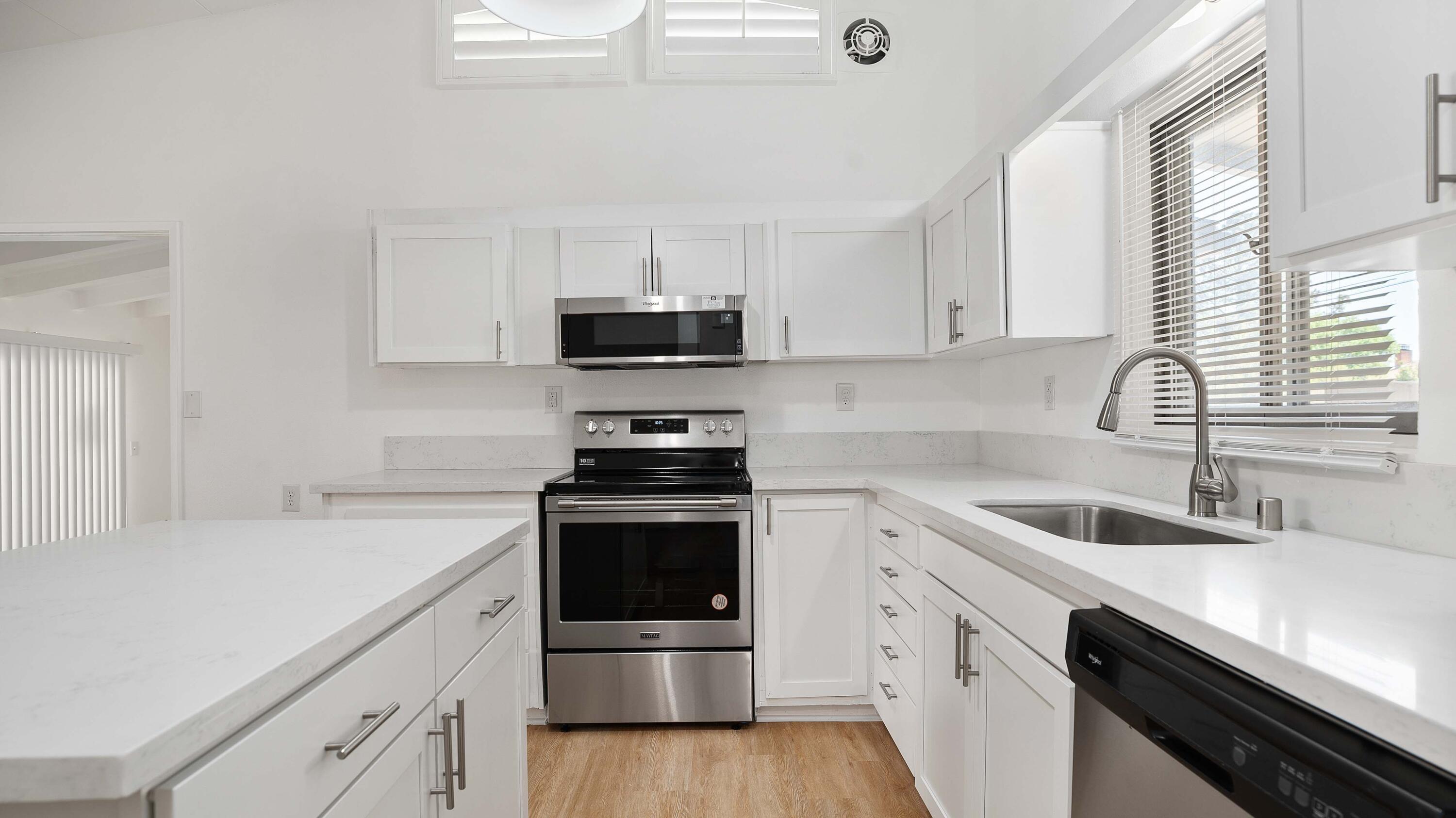 a kitchen with stainless steel appliances a sink a stove and microwave