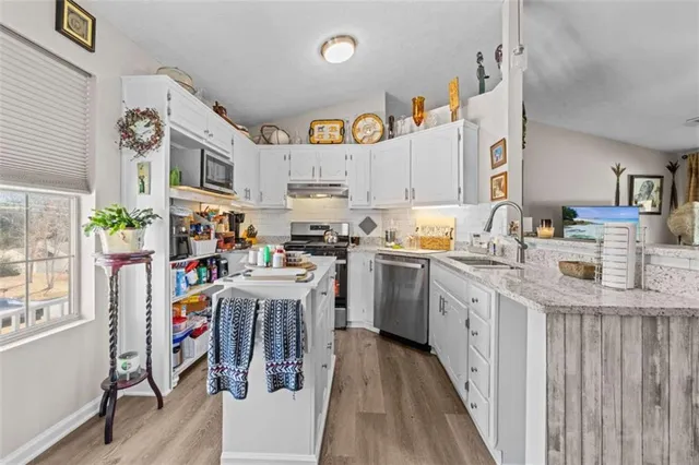 a kitchen with cabinets and wooden floor