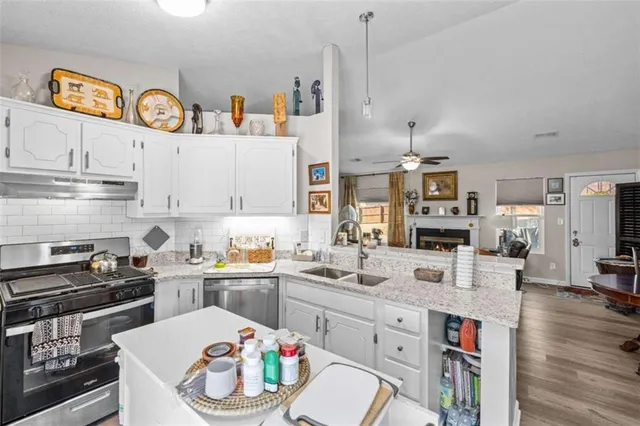 a kitchen with a sink stove top oven and cabinets