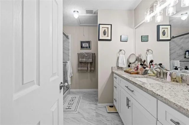 a bathroom with a granite countertop sink and a mirror