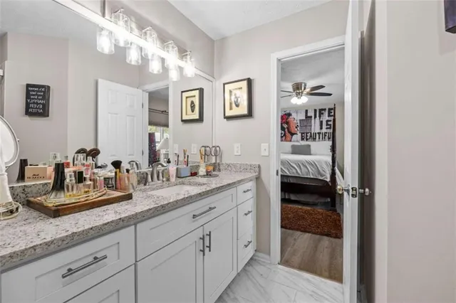 a en suite bathroom with a granite countertop sink and a mirror