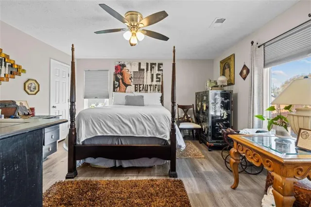 a bedroom with a bed a dresser and chair
