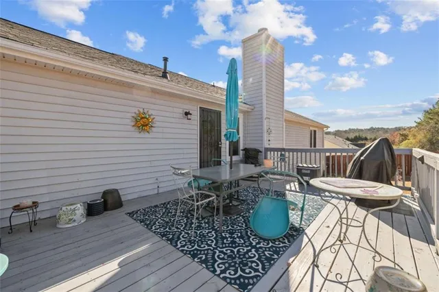 a view of a roof deck with dining table and chairs