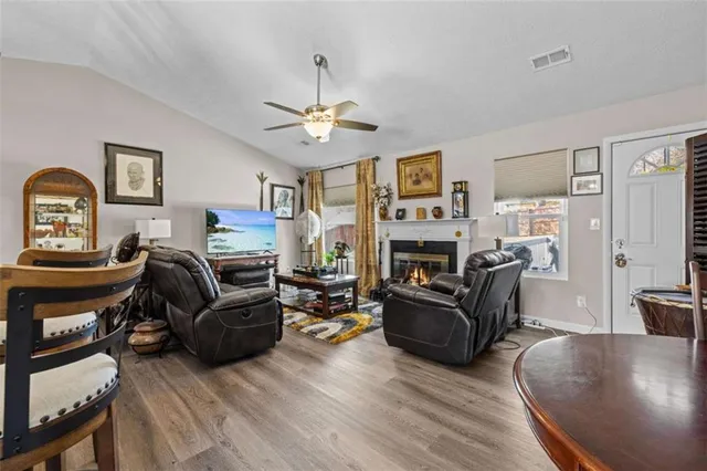 a living room with furniture a fireplace and a flat screen tv