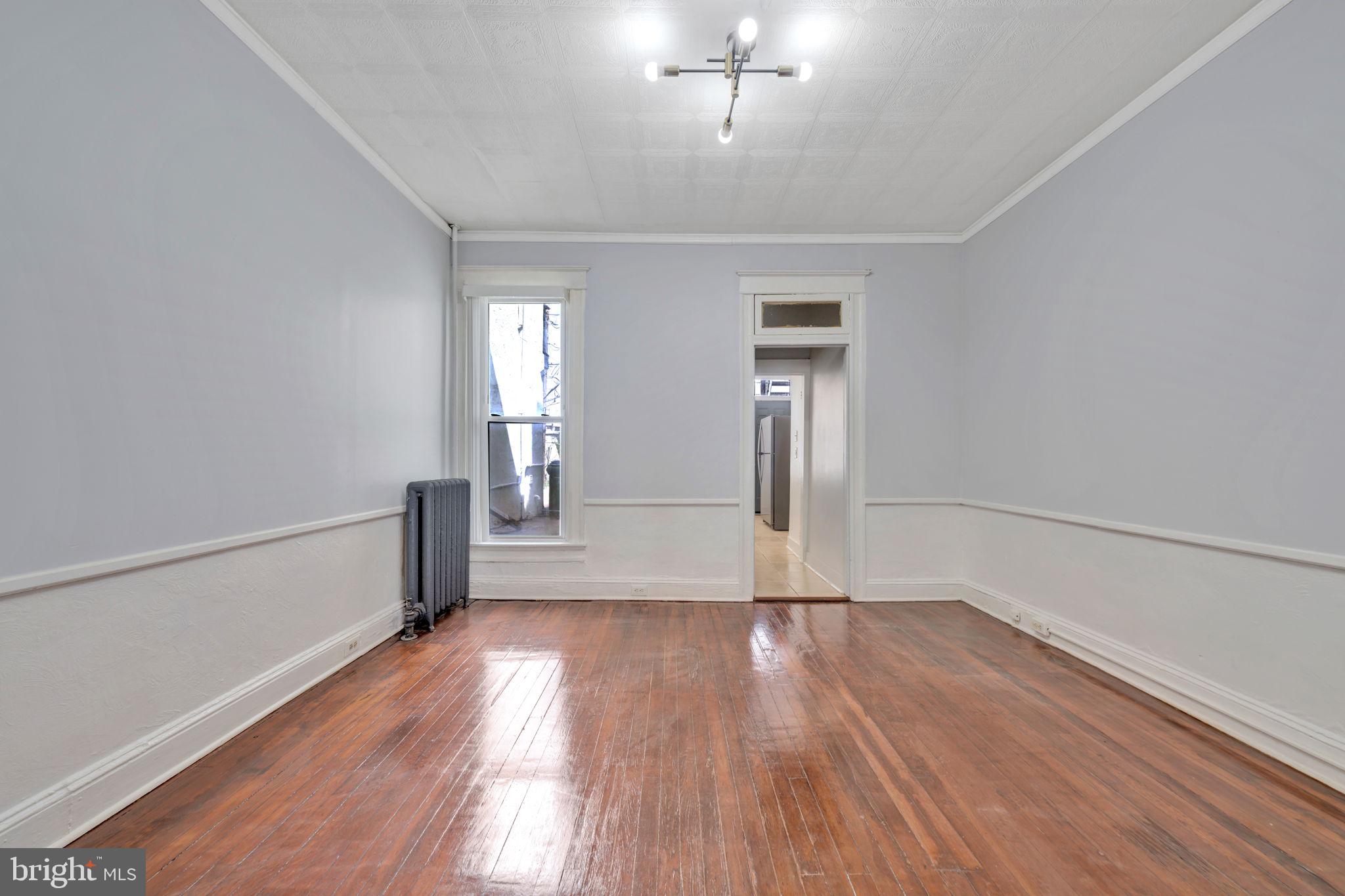 2822 Riggs Avenue Baltimore, MD 21216 - Photo 9 of 30 a view of an empty room with wooden floor and a window