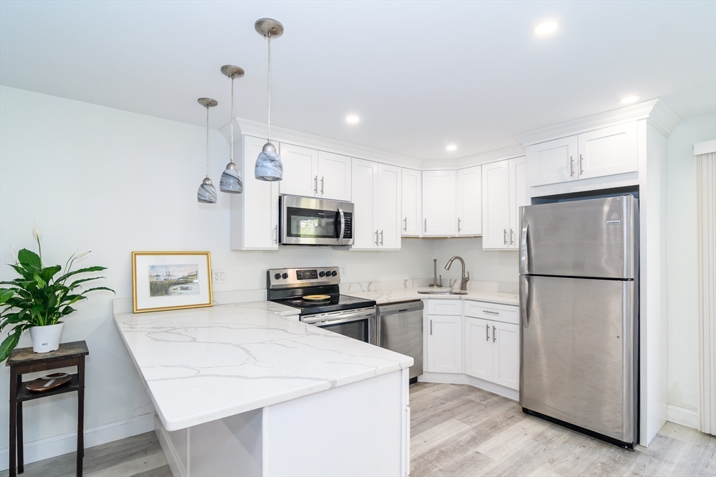 a kitchen with white cabinets and white appliances
