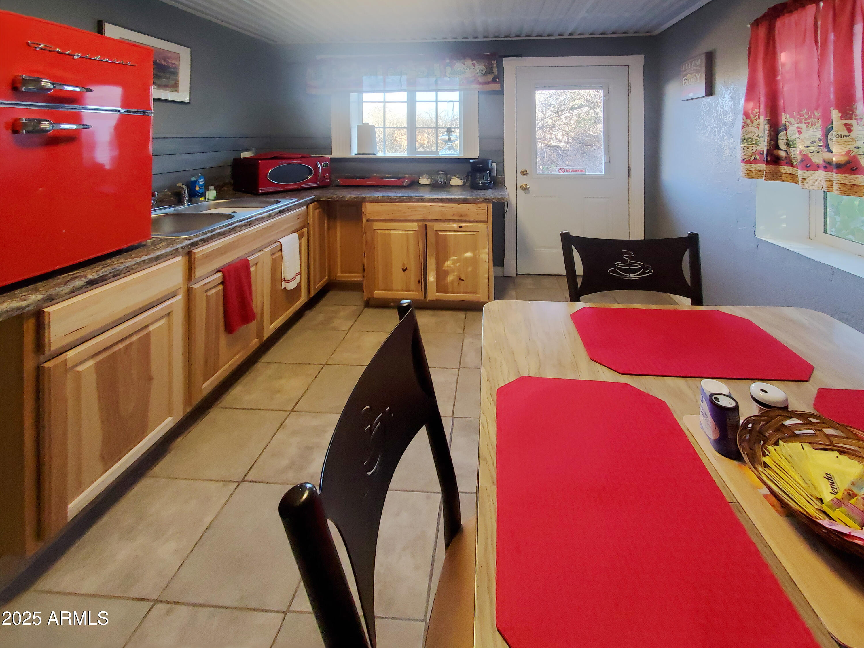 116 North 3rd Street Tombstone, AZ 85638 - Photo 40 of 64 a kitchen with stainless steel appliances kitchen island granite countertop a dining table chairs and a refrigerator