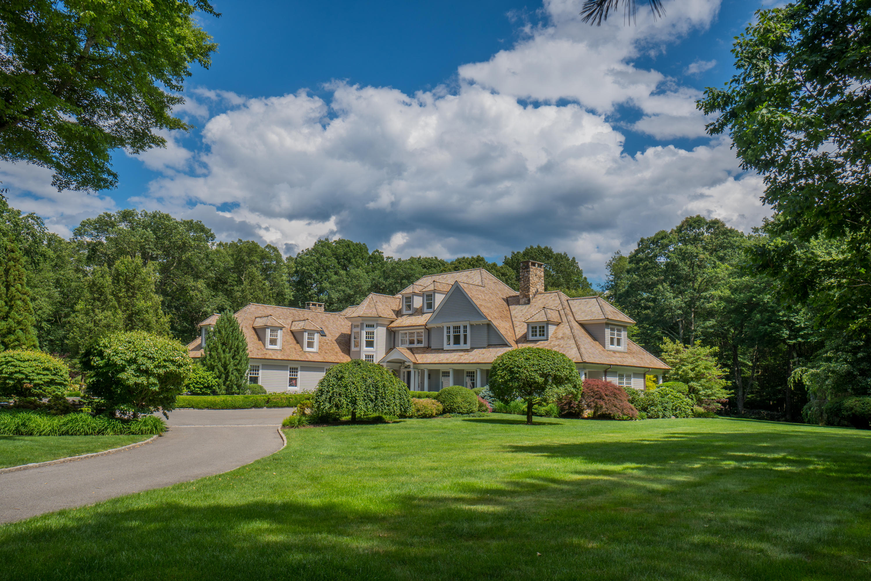 85 Lukes Wood Road New Canaan, CT 06840 - Photo 1 of 40 a front view of a house with a garden