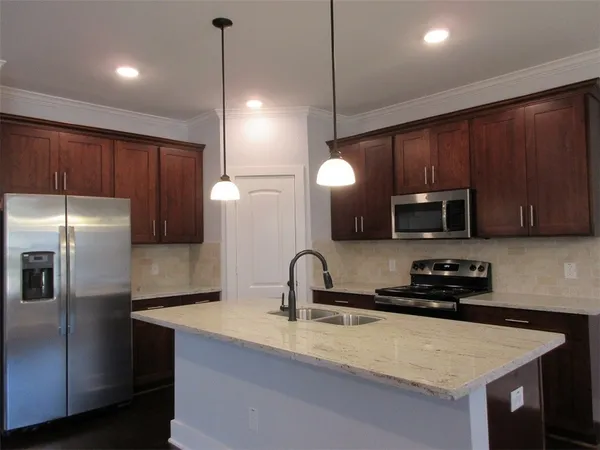 a kitchen with sink a refrigerator and cabinets