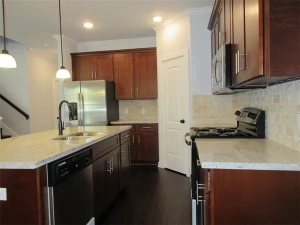 a kitchen with stainless steel appliances a sink stove and cabinets