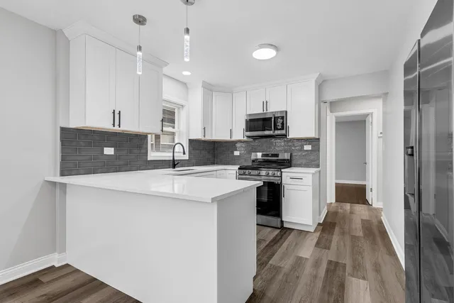 a kitchen with stainless steel appliances a stove refrigerator sink and microwave