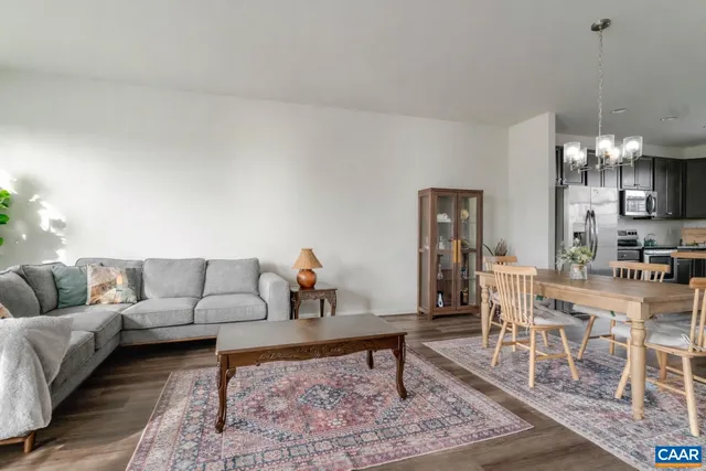 a living room with furniture a dining table and a chandelier