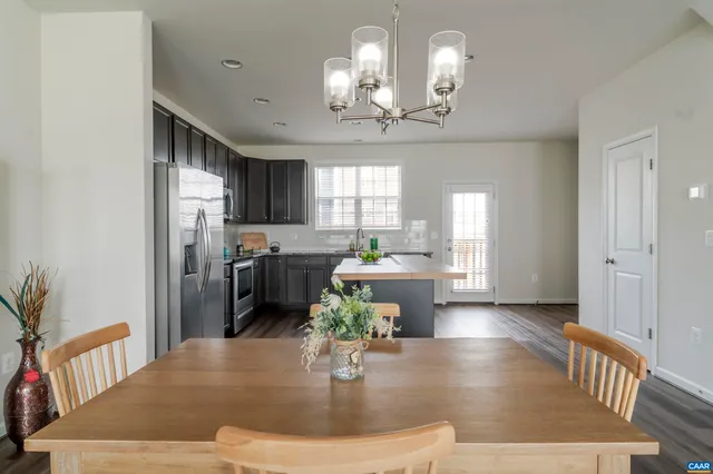 a living room with couches chairs and chandelier